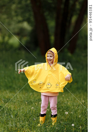 Happy girl in a bright yellow raincoat. Happy girl in a bright yellow raincoat. 95446381