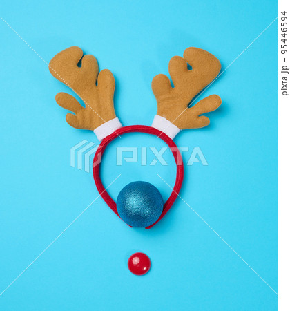 Christmas deer costume with antlers on the head on a blue background, top view. 95446594