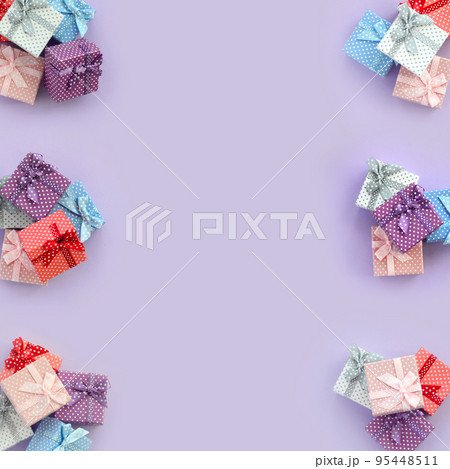 Piles of a small colored gift boxes with ribbons lies on a violet background. Minimalism flat lay top view pattern 95448511