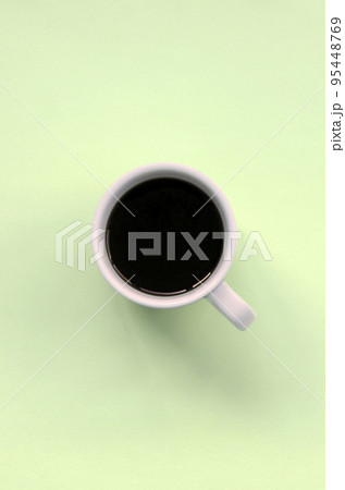 Small white coffee cup on texture background of fashion pastel lime color paper Small white coffee cup on texture background of fashion pastel lime color paper 95448769