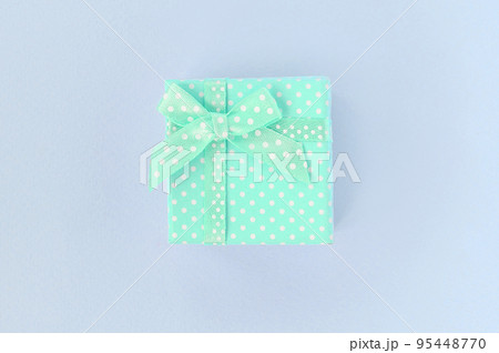 Small blue gift box with ribbon lies on a violet background 95448770