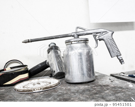 paint spray gun on wood table in car repair service center 95451501