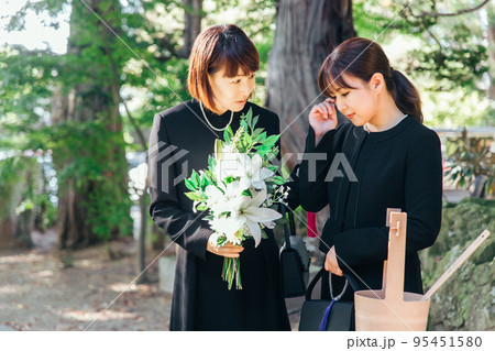 お葬式で泣く遺族と慰める日本人女性 95451580