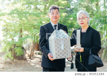 お葬式で火葬した遺骨を持つ日本人の高齢者夫婦 95451584