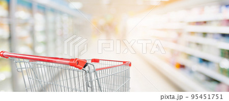 Supermarket aisle blur defocused background with empty red shopping cart Supermarket aisle blur defocused background with empty red shopping cart 95451751