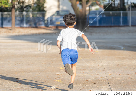 学校の校庭を走っている小学生の男の子 95452169