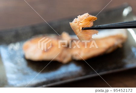 北海道産の焼き鮭を箸で持ち上げている 95452172