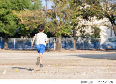 学校の校庭を走っている小学生の男の子 95452176