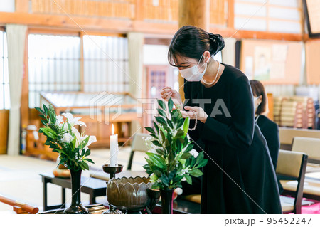 お葬式でお焼香する喪服姿の女性 95452247