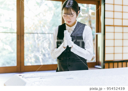 仏衣を着せる葬儀スタッフ（納棺師・合掌） 95452439