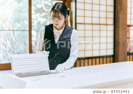 棺桶の覗き窓を開ける葬儀スタッフ（納棺師） 95452441