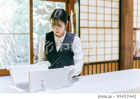 棺桶の覗き窓を開ける葬儀スタッフ（納棺師） 95452442