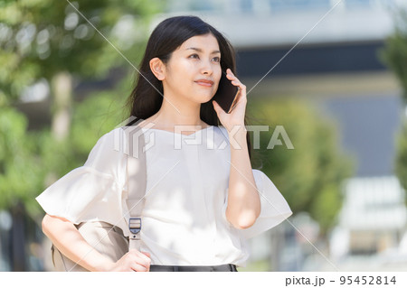 リュックを背負ってスマホで電話するビジネスウーマン リュックを背負ってスマホで電話するビジネスウーマン 95452814