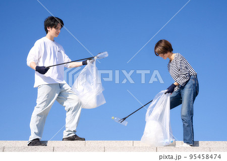 晴天の屋外でゴミ拾いをする若い男女　ボランティア　清掃　イメージ 95458474