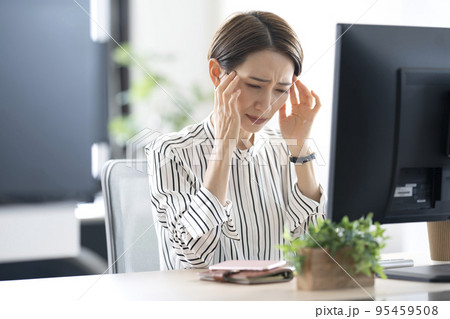 仕事中に頭痛が辛い女性 95459508