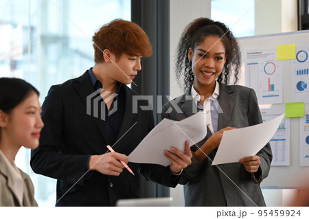 Group of young business people discussing financial graphs, working on corporate project at briefing meeting 95459924