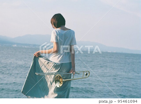 海辺で楽器を楽しむ女性 95461094