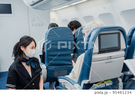 マスクをして機内サービスをする客室乗務員 95461234