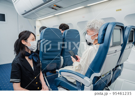 マスクをして機内サービスをする客室乗務員 95461235