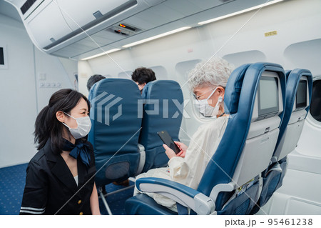 マスクをして機内サービスをする客室乗務員 95461238