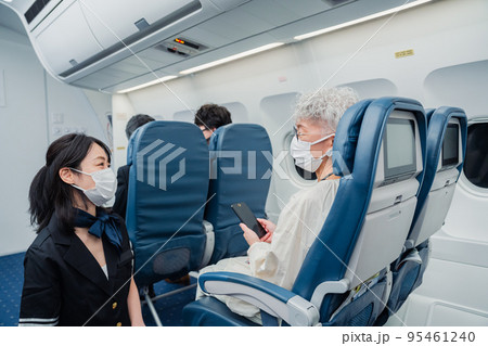 マスクをして機内サービスをする客室乗務員 95461240