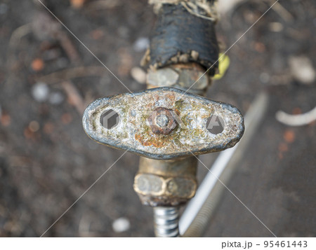 Old plumbing water tap with a metal valve. Old plumbing water tap with a metal valve. 95461443