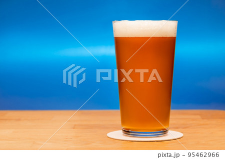 Full shaker pint glass of ale or beer on a table Full shaker pint glass of ale or beer on a table 95462966