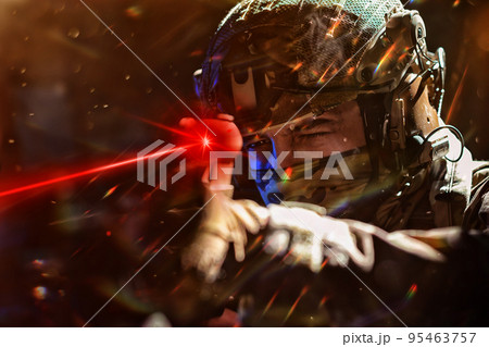 Army soldier in Combat Uniforms with an assault rifle and combat helmet night mission dark background. Blue and purple gel light effect. Army soldier in Combat Uniforms with an assault rifle and combat helmet night mission dark background. Blue and purple gel light effect. 95463757