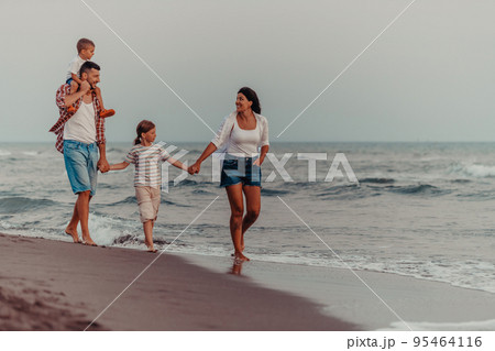 Family gatherings and socializing on the beach at sunset. The family walks along the sandy beach. Selective focus  95464116