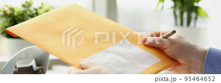 Man holding yellow envelope and going to fill in personal address on cover 95464652