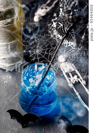 Blue cocktail for halloween party in glass with bubbling and smoke. 95464808