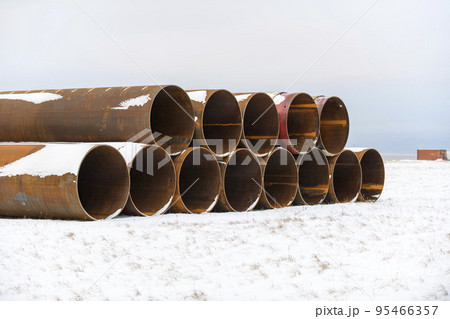 Large tubes in winter tundra. Construction Marine offshore works. Dam building. 95466357
