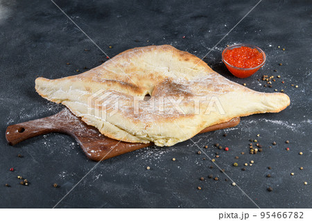 Georgian bread lavash with red caviar on wooden board on dark rustic background, top view Georgian bread lavash with red caviar on wooden board on dark rustic background, top view 95466782