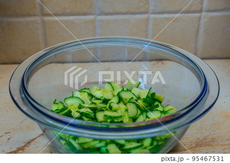 sliced of fresh cucumber in a glass bowl 95467531