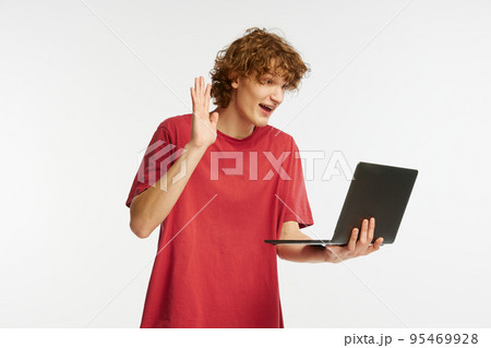Hello. Caucasian man's portrait isolated on white studio background. Emotional boy using laptop for studying. Concept of human emotions, facial expression Hello. Caucasian man's portrait isolated on white studio background. Emotional boy using laptop for studying. Concept of human emotions, facial expression 95469928