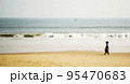 Woman carrying a basket on the beach 95470683
