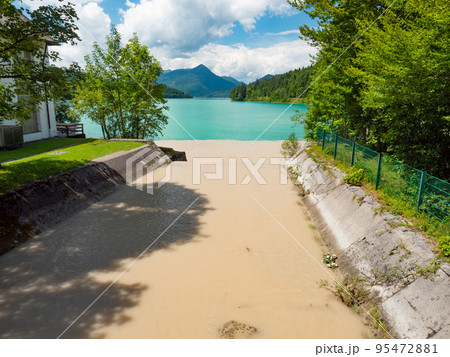 Muddy river tributary from the peaks of the Dolomites Alps after heavy rain. The riverbed feeds the current to the hydroelectric power plant and on to the Walchensee 95472881