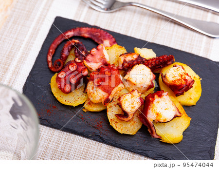 Portion of polbo a feira served on board 95474044