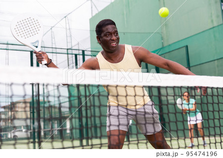 Sporty emotional man playing doubles paddle tennis 95474196