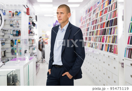 Insecure man can't choose a phone case at store 95475119