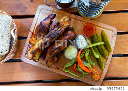 Baked pork ribs with pickles cucumbers and pepper.  95475491