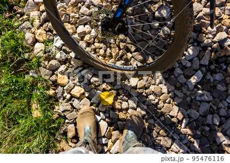 Mud on boots and on bicycle wheels after a muddy stretch of road 95476116