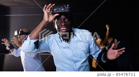 Man using virtual reality headset and smiling 95476711