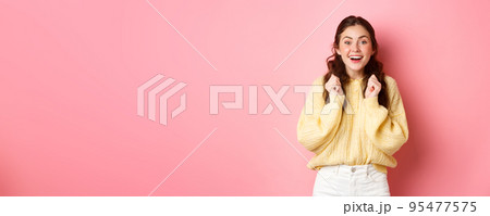 Image of hopeful lucky girl looking at camera, wants to win, waiting for important results, standing against pink background 95477575