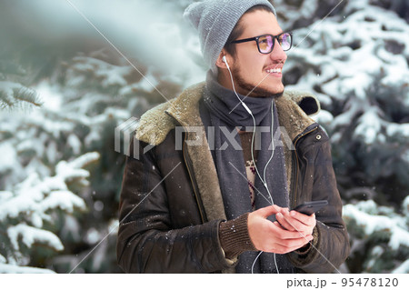 Outdoor close up portrait of young beautiful men. Smiling young man having fun outdoors. Snowfall. 95478120