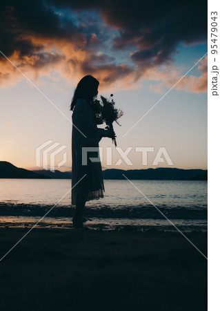 海辺で佇む女性のシルエット写真 海辺で佇む女性のシルエット写真 95479043