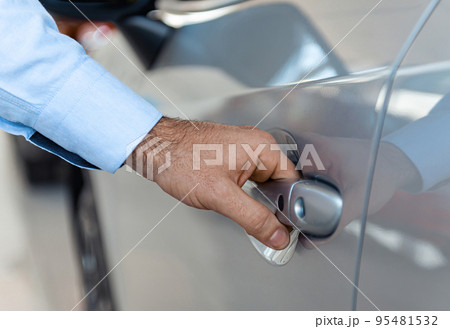 Close up of a male customer hand opening a car door at the dealership Close up of a male customer hand opening a car door at the dealership 95481532