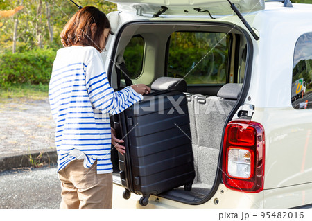 車にスーツケースを運ぶ女性 95482016