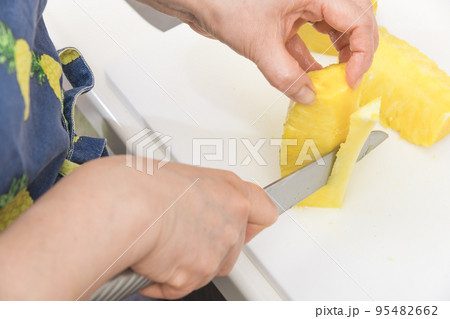 【皮削ぎの終わったパイナップルの芯を切っていく】 【皮削ぎの終わったパイナップルの芯を切っていく】 95482662