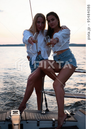 Young women on yacht at sunset 95484086